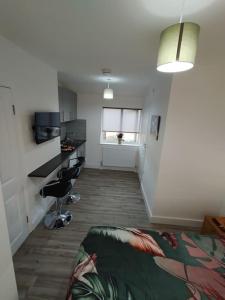 a room with a bed and a desk and a window at Stylish studio flat with Parking in Enfield