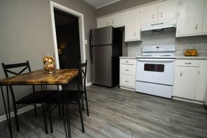 een keuken met een tafel, een fornuis en een koelkast bij ZEN'S Retreat in North Little Rock