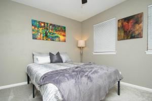 een slaapkamer met een bed en twee schilderijen aan de muur bij ZEN'S Retreat in North Little Rock