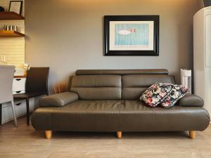 un divano marrone con un cuscino in soggiorno di Aewol Bada Poomeun Property a Jeju