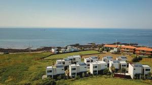 a row of houses on a hill next to the ocean at Aewol Bada Poomeun Property in Jeju