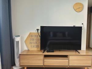 a flat screen tv sitting on top of a wooden entertainment center at Aewol Bada Poomeun Property in Jeju