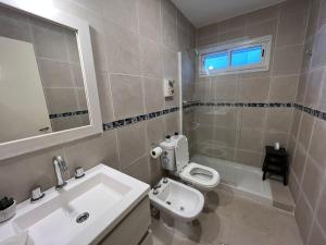 een badkamer met een wastafel, een toilet en een spiegel bij CASA EN YERBA BUENA in Yerba Buena