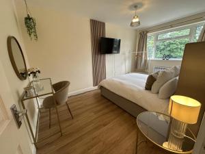 a bedroom with a bed and a table and chairs at Charming 2-Bed Apartment in Danbury essex in Chelmsford