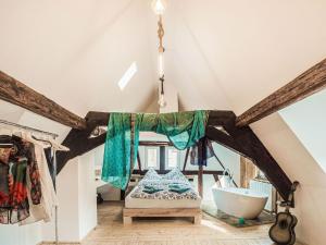 a room with a bed and a tub in a attic at Cosy holiday home in Sankt Goarshausen with barbecue in Sankt Goarshausen