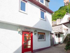 a red door on the side of a white building at Holiday home in Sankt Goarshausen with barbecue in Sankt Goarshausen