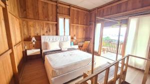 a bedroom with a bed and a balcony at Panorama Ekas in Ekas
