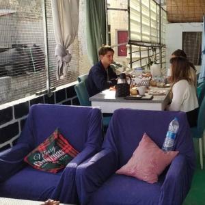 un homme et une femme assis à une table dans une pièce dans l'établissement In The Heart Of Praia - Family B&B, à Praia