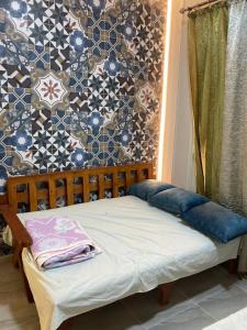 a small bed in a room with a wall at Pharma beach resort قريه الصيادلة - Chalet - zero ten six four one seven six five zero nine in Balṭîm