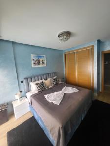 a bedroom with a bed and a blue wall at Appartement de luxe sur agadir bay in Agadir