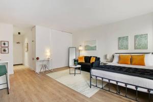 a bedroom with a large bed and a living room at Serene & Completely Furnished Studio Apartment- Chestnut 14F in Chicago