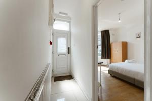 Habitación blanca con cama y puerta en Plaistow Cosy Double Rooms - 8, en Londres