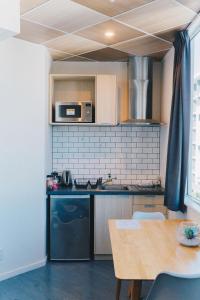 a small kitchen with a table and a microwave at Liberty Apartment Hotel in Wellington