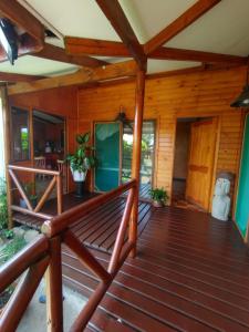 eine Veranda eines Holzhauses mit einer Bank in der Unterkunft Hostal Makohe Rapa Nui in Hanga Roa