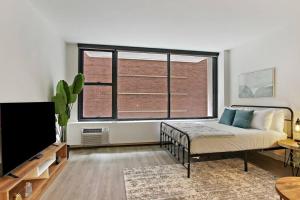 a bedroom with a bed and a large window at Inviting Fully Furnished Studio Perfect Location- Chestnut 02D in Chicago