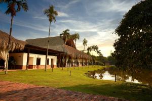 um edifício com palmeiras ao lado de uma massa de água em Hotel Reserva de Piedemonte em Villavicencio