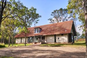 a house with a red roof in the woods at Wandin Valley Estate in Lovedale