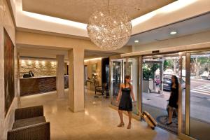 twee vrouwen die in een lobby van een winkel lopen bij Hotel Regina Margherita in Cagliari