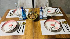 a wooden table with plates and utensils on it at Appartement INES Saidia in Saïdia