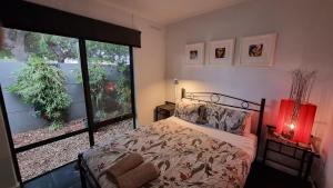 um quarto com uma cama e uma grande janela em The Good Life em Port Pirie