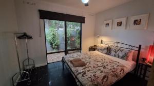 a bedroom with a bed and a large window at The Good Life in Port Pirie