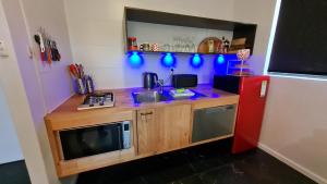 a kitchen with a counter with a microwave and a refrigerator at The Good Life in Port Pirie