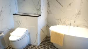 La salle de bains est pourvue d'un lavabo, de toilettes et d'une baignoire. dans l'établissement The George Penang by The Crest Collection, à George Town