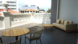 a balcony with a couch and a table and chairs at The George Penang by The Crest Collection in George Town