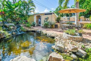 a backyard with a pond and an umbrella at Banyan House Vacation Rentals in Venice