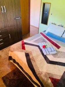 a bedroom with a bed with a quilt on it at Hospedagem Colinas in Aiuruoca