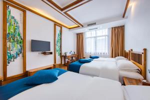 Zimmer mit 4 Betten und einem Flachbild-TV in der Unterkunft Guihua Road 106th Hostel in Zhangjiajie