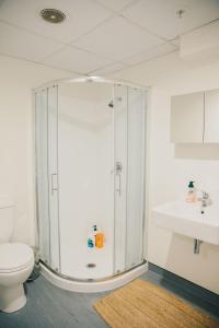 a bathroom with a shower and a toilet and a sink at Liberty Apartment Hotel in Wellington