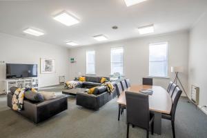 un soggiorno con un divano, un tavolo e delle sedie di 4 Bedroom House - Hobart CBD - Free Parking - Free WIFI a Hobart