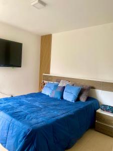 a bedroom with a blue bed with a flat screen tv at Apartamento luxury en sabaneta in Sabaneta