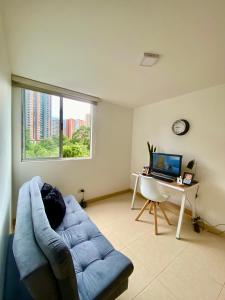a living room with a blue couch and a desk at Apartamento luxury en sabaneta in Sabaneta