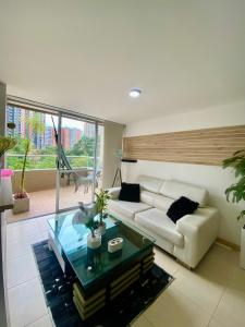 sala de estar con sofá blanco y mesa de cristal en Apartamento luxury en sabaneta, en Sabaneta
