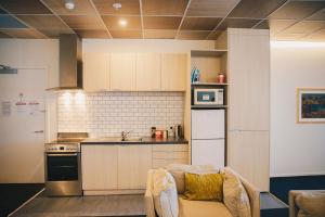 a small kitchen with a couch and a stove at Liberty Apartment Hotel in Wellington