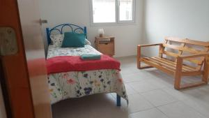 1 dormitorio con cama y silla de madera en Duplex Bosch en Neuquén