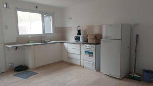 a kitchen with a white refrigerator and a microwave at Duplex Bosch in Neuquén +14 photos