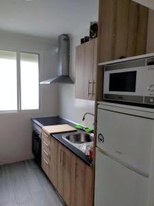 a small kitchen with a sink and a microwave at Apto a 5 min a pie de la playa in Málaga