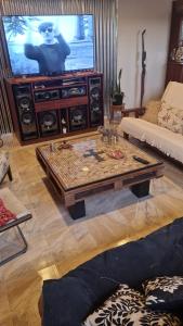 Una sala de estar con televisión y una mesa de café. en Finca san benito, en Puerto Madryn