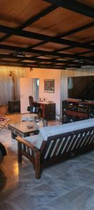 a living room with a couch and a large screen tv at Finca san benito in Puerto Madryn