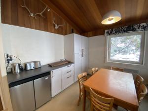 a kitchen with a wooden table and a table and chairs at Mount Buller Apartment in Mount Buller