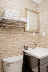 W łazience znajduje się toaleta, umywalka i lustro. w obiekcie Sheer Bliss BeachView Apt #2 w mieście Exuma Harbour Estates