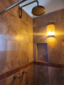 La salle de bains est pourvue d'une douche avec une lumière sur le mur. dans l'établissement Hotel Santa Irene, à Cholula