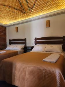 2 camas en una habitación de hotel con en Hotel Santa Irene en Cholula