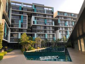 un edificio de apartamentos con piscina frente a él en Little Fox Nest at KLIA Sepang and Gamuda SplashMania en Sepang