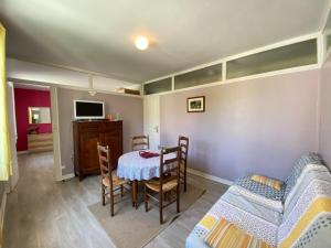 a dining room with a table and chairs and a tv at Apartment in Arromanches near Sandy Beach in Arromanches-les-Bains