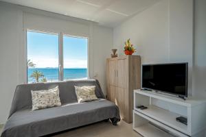 a living room with a couch and a flat screen tv at Inmosantos Oasis F5 in Roses