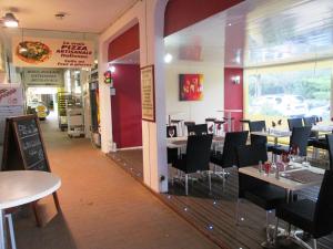 un comedor con mesas y sillas en un restaurante en Vittoria Immobilier 3 - Vue Dégagée - Terrasse - chèques vacances acceptés, en La Grande-Motte